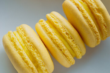 Close up of three yellow lemon flavoured French macaron pastries