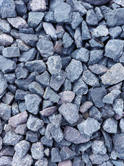 Background of natural granite crushed stone, macadam. Macro photo of texture of broken stone or rubble with place for text