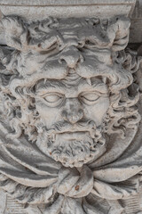 Bas-relief of an old sculpture of scary mythical worrier with leopard skin at his head as a gatekeeper in historical downtown of Dresden. Concept of art and historical heritage.