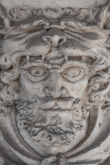 Bas-relief of an old sculpture of scary mythical worrier with leopard skin at his head as a gatekeeper in historical downtown of Dresden. Concept of art and historical heritage.