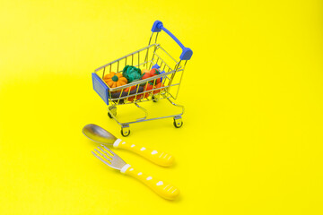 Metal shopping cart with grocery and products. Organic vegetables for baby healthy diet. Delivery concept