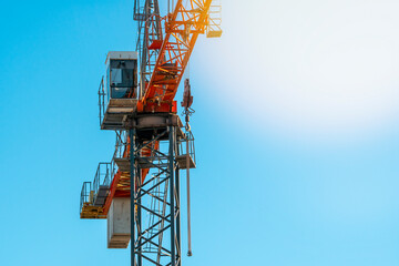 Top of a crane with a boom and a cabin for crane operator