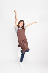 Portrait of Happy Young Asian woman workers fresh market or coffee show staff with brown apron standing and hands up raised arms from happiness, Excited or winner success concept