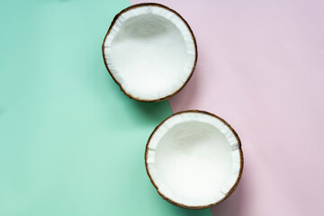 Halved coconut on blue and pink pastel color geometric background