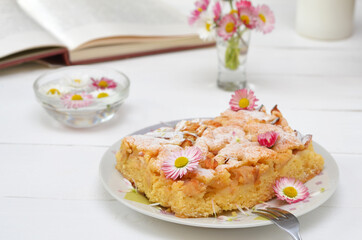beautiful still life of pie on a plate, flowers and a book in the background