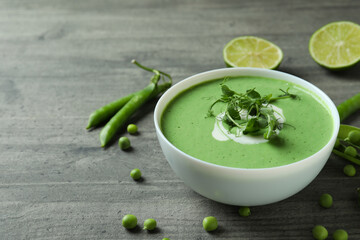 Concept of tasty eating with pea soup on gray textured table