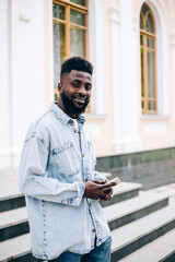 Young handsome black businessman using phone outdoors.