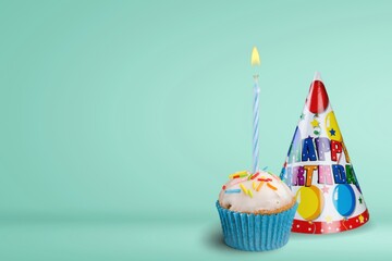 Birthday cupcake with one birthday candle and  party hat