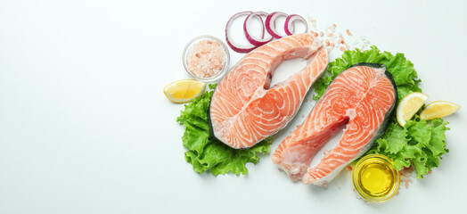 Fresh raw salmon and ingredients for cooking on white background