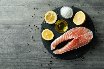 Concept of cooking salmon on gray textured background