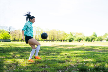 Young woman practicing soccer skills with ball.