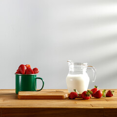 Fresh strawberries on a wooden kitchen table and shadow on the wall 