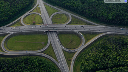 AERIAL. Traffic interchange. Top view of the road, city and forest. Summer video from the drone.