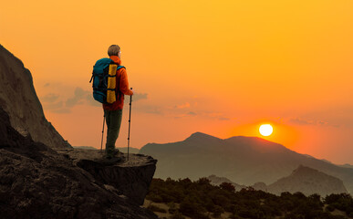 tourist - backpacker in touristic equipment stand on mountain peak