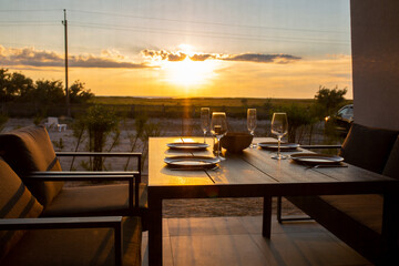 Laid table for four on the summer terrace.Summer terrace for friends.Dinner on the terrace.Table setting on the street.Summer dinner.Waiting for guests.Laid table for the family.Dinner in the summer.G