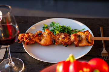 A picnic on the terrace for friends.Terrace with barbecue at sunset.Fried meat on the street at home. Kebab.Grilled meat is served at home.Grilled meat with wine and vegetables.Summer on the terrace.