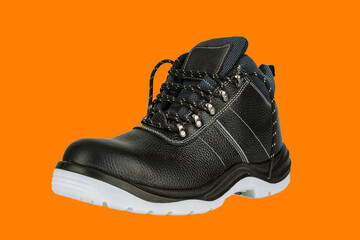 A working black leather boot with a thick gray sole on a orange background. There are fabric inserts. The shoes are new and clean. The laces are untied. The image is isolated.