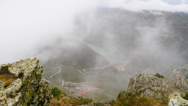 Mountain and Douro river with spanish Saucelle Dam at foggy cloudy weather. Border between Portugal and Spain. National Parks. View from portuguese Penedo Durao lookout.