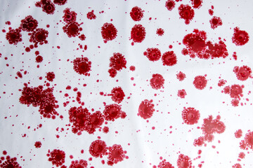 Red drops of paint on a white background, similar to coronavirus molecules