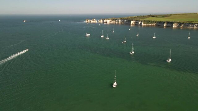 flying over jetski and boats near the shore on beautiful summer day and calm clear waters, aerial drone video, 4K