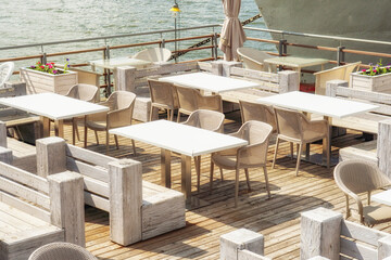 Empty tables in restaurant on barge on river, sea during quarantine