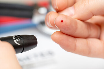 Taking blood for diabetes sugar level medical test from finger