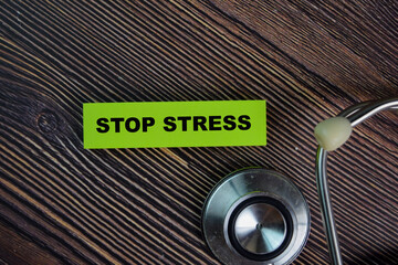 Stop Stress write on sticky notes isolated on Wooden Table. medical concept