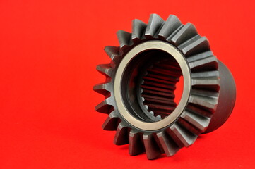 Cogwheel ​on the red background. Spare parts