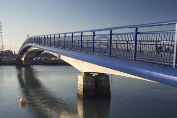 Blue bridge and safety rails crossing body of water