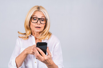 Photo portrait of shocked amazed surprised senior mature woman holding mobile phone seeing crazy...