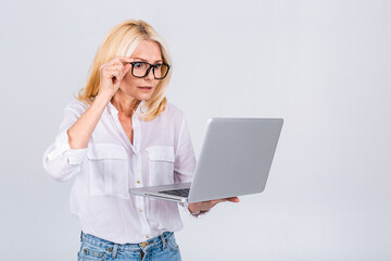 Photo of amazed shocked surprised senior mature old woman holding laptop computer isolated on white grey background.