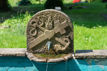Brunnen, Wasserstelle mit kirchlichen Ornamenten