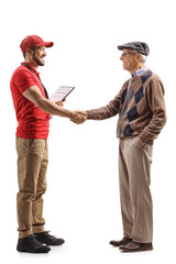 Fototapeta premium Full length profile shot of a delivery man shaking hands with a pensioner