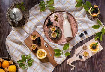 Flat lay food photography of a passion fruit smoothie bottle with blackberries. Top view of a...