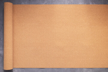 Roll of cork at concrete floor background texture. Corkboard at wall background