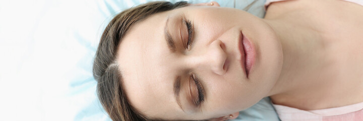 Portrait of woman with closed eyes lying in bed