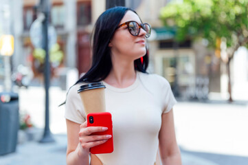 Portrait of pretty woman with sunglasses in the city drinking takeaway coffee.