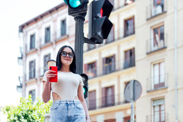 Woman having takeaway coffee in the city street.