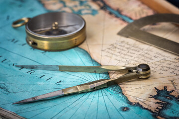 An old geographic map with navigational tools: compass, divider, ruler, protractor. View of the...