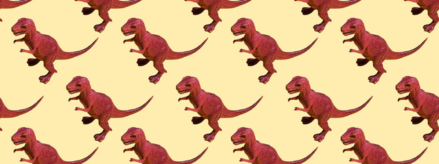 Toy plastic dinosaur on a colored background. Seamless pattern concept for texture, design, wallpaper, decor, textile. Banner
