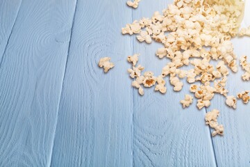 Tasty popcorn fell spilled on wooden desk