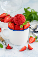 Strawberry sorbet with mint and fresh berries in a white cup. Fruit berry  summer ice cream. Vegetarian healthy dessert. Selective focus 