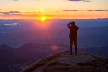Obraz premium Man in top of mountain photographing the beautiful landscape at sunrise
