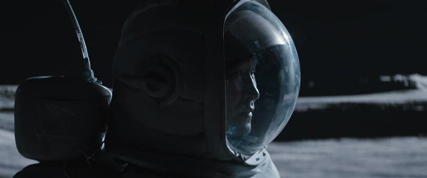 CU Portrait of Asian lunar astronaut opens his visor while exploring Moon surface. Shot with 2x anamorphic lens