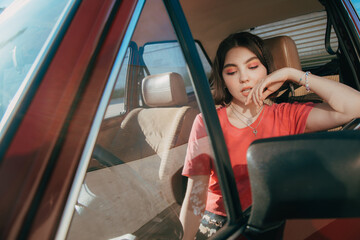 Naklejka premium Girl pondering while sitting behind the wheel at the driver's seat