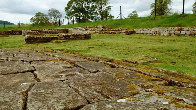 Walking the ruins of Housesteads Roman Fort on Hadrian's Wall, built by the Romans in AD 124 in Northumberland, England, UK. Hadrian's Wall is a UNESCO World Heritage Site