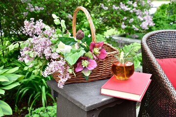 Backyard garden oasis with beautiful bouquet of seasonal cut flowers and glass of ice tea beverage...