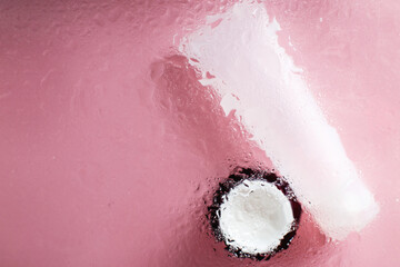 Fototapeta premium natural moisturizing skin care products. Face and hand cream under a glass surface with water on a pink background