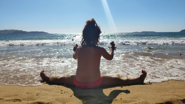 Girl playing with the sand in Samil beach