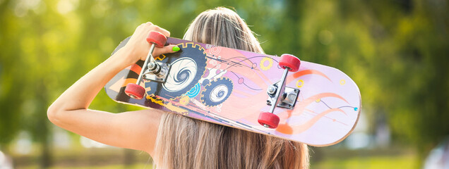 Girl with skateboard on her shoulders. Back, skate © MR.PLAY